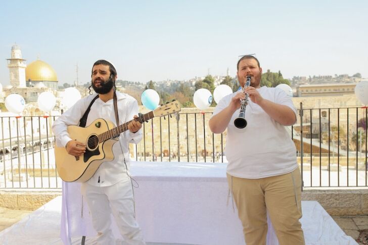 שני נגנים בלבוש לבן מסורתי על גיטרה וקלרינט